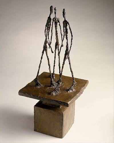 Alberto Giacometti — three slender bronze figures on a raised square base.